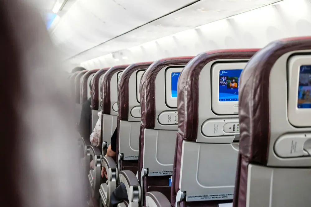 Rear view of inflight economy class cabin seats of an airplane.